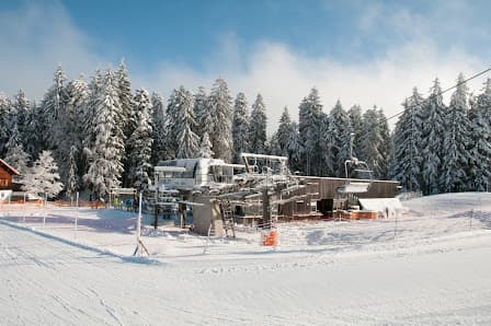 Breathtaking view of Bödele ski resort in Austria featuring picturesque snow-covered slopes, ski lift infrastructure and vibrant winter sports scene, showcasing an appealing winter paradise.