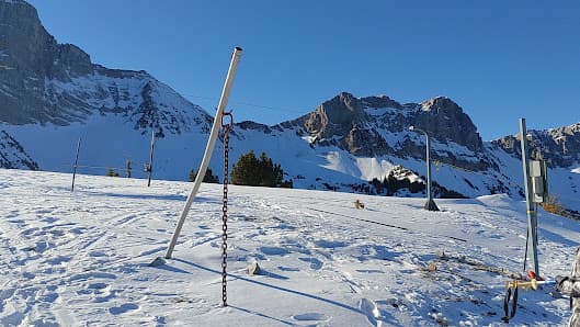 A winter sports scene at Gresse en Vercors in France showcasing a sports centre a quaint chalet a skier in action