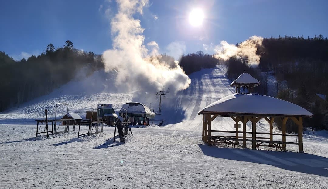 Winter sports enthusiasts enjoy the slopes at Mont Ste-Marie ski resort in Lac-Sainte-Marie, Quebec, Canada. The stunning winter landscape and ski lift add to the serene atmosphere.