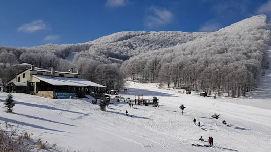 Winter scene at Vigla Pisoderi in Verno, Florina, Greece, featuring a bustling ski resort with ski lifts in operation amidst stunning snow-covered scenery.