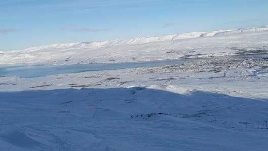 Winter sports scene at Hlíðarfjall in Iceland, with a chalet nestled on the snowy mountainside, amidst a stunning winter landscape, serving as a sports centre.