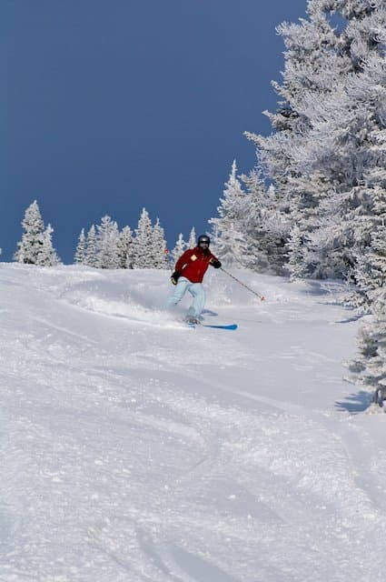 A skier carving down the pristine slopes of Murray Ridge in Fort St James British Columbia Canada. The ski resort complete with ski lift and chalet