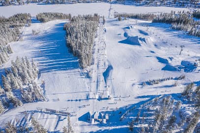 Winter sports scene at Tahko Ski Resort in Kuopio, East Finland, featuring a skier on the slope and a ski lift in the background.