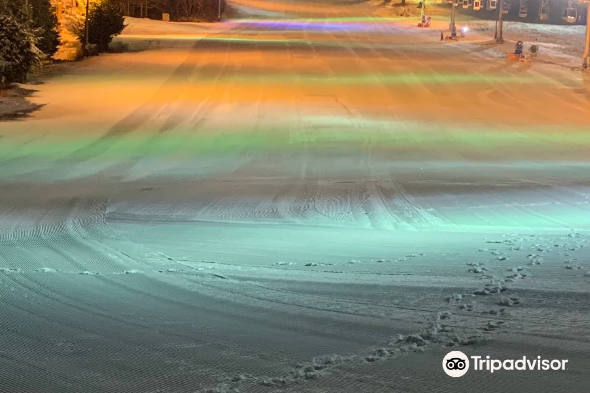 Winter sports enthusiasts enjoy a vibrant day at Echo Valley, Nagano, Japan. The scene is adorned with a snowmobile, complexities of a ski resort, and breathtaking winter scenery all around.