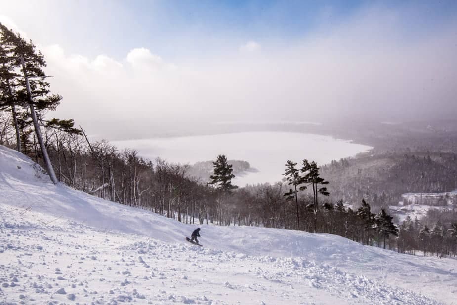 A skier enjoys the pristine slopes at Mt Bohemia ski resort in Mohawk, Michigan, USA, surrounded by the stunning beauty of a wintery landscape.