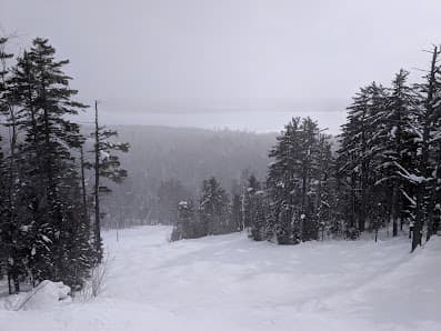 A picturesque winter sports scene at Mt Bohemia in Mohawk Michigan featuring a ski resort snow-covered slopes
