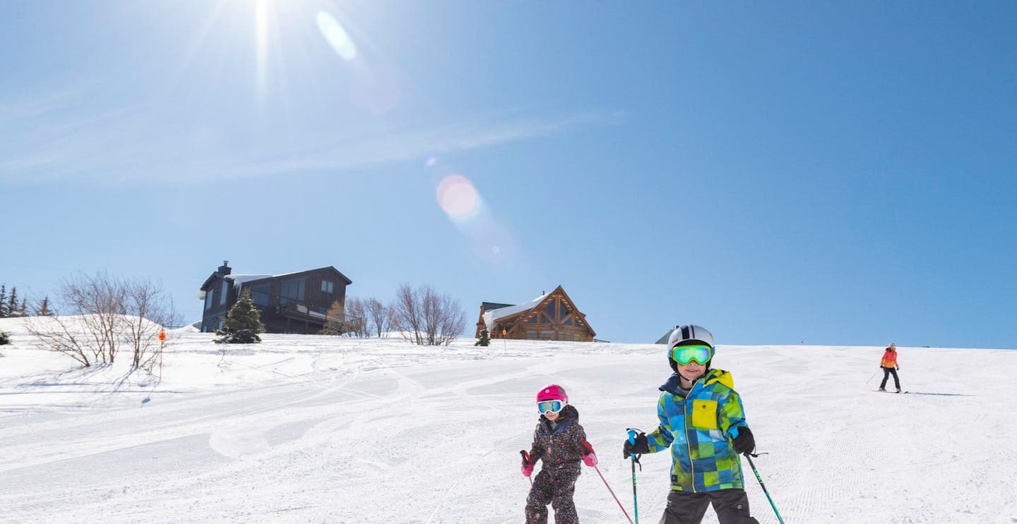 Tahoe Donner in USA - two people skiing down a snow covered hill.