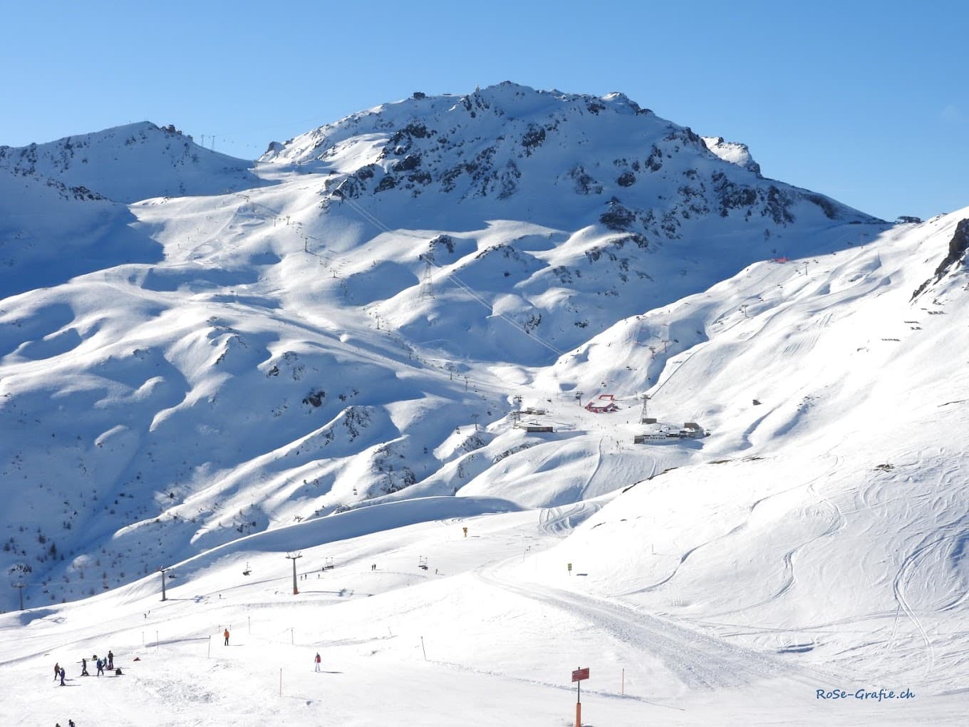 A charming chalet sits nestled in the snowy landscape of Parsenn ski resort in Davos Switzerland embodying the essence of winter sporting life with pristine slopes in the background.