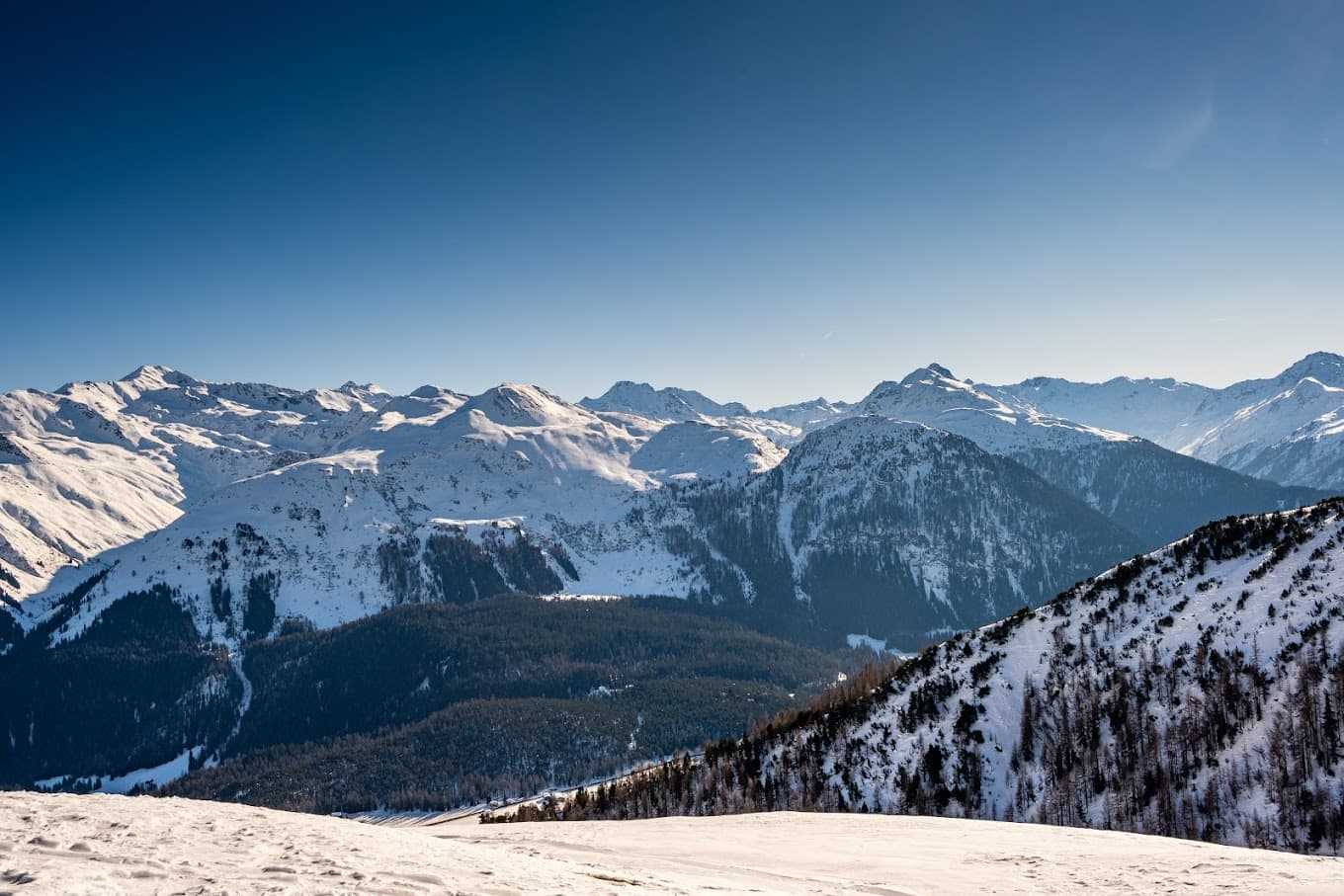 Winter sports scene at Parsenn ski resort in Davos Switzerland showcasing skiers on the mountainside a charming challet in sight surrounded by the breathtaking winter scenery.