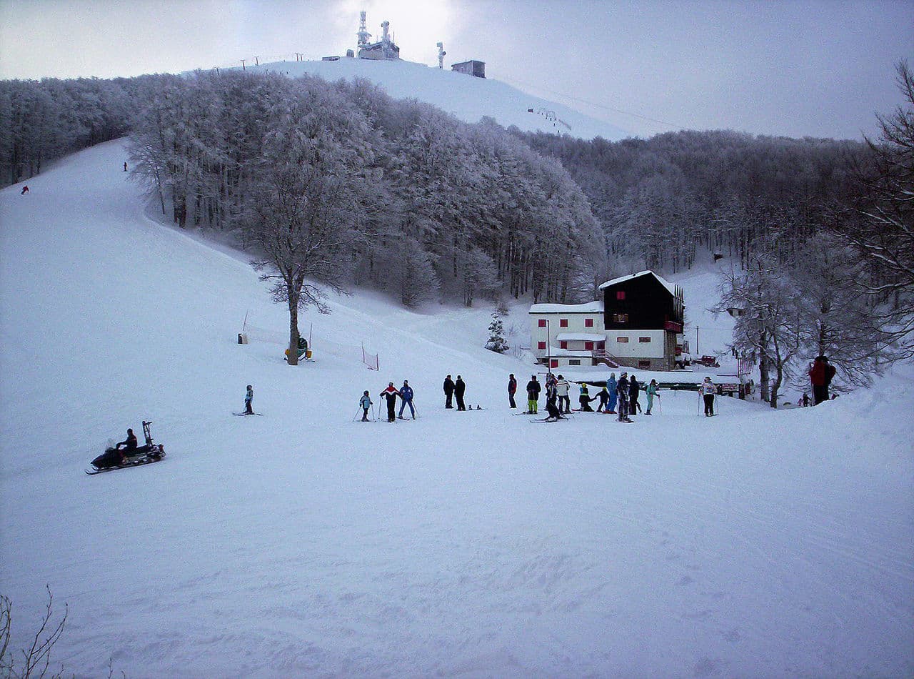 Monte Terminillo in Italy - a group of people skiing down a snowy hill.