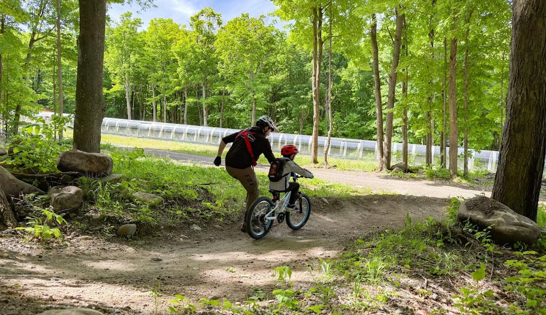A mountain bike is prominently featured in this image indicating a biking activity at Mont Rigaud in Quebec Canada. There's a slight hint of a chalet in the distance.