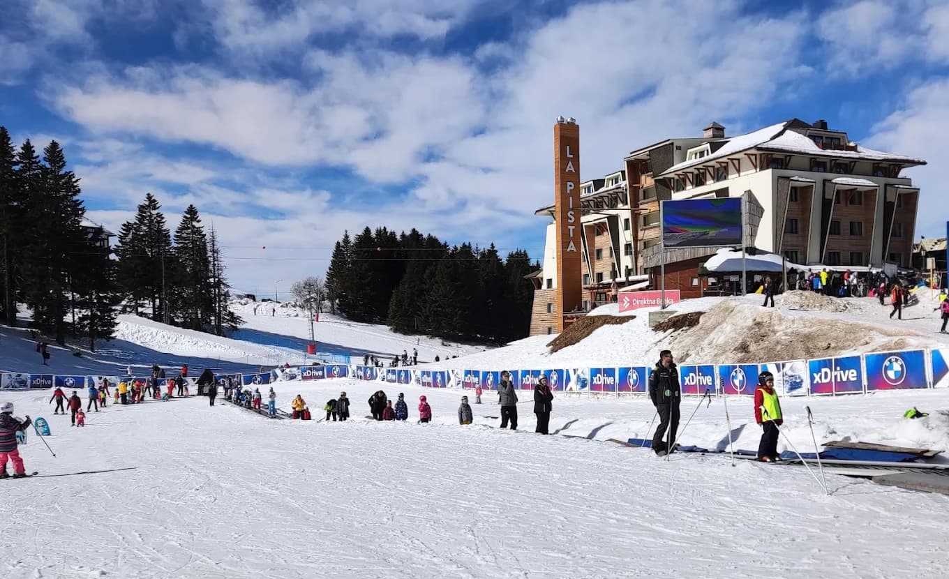 Kopaonik in Serbia - a group of people skiing down a snow covered slope.