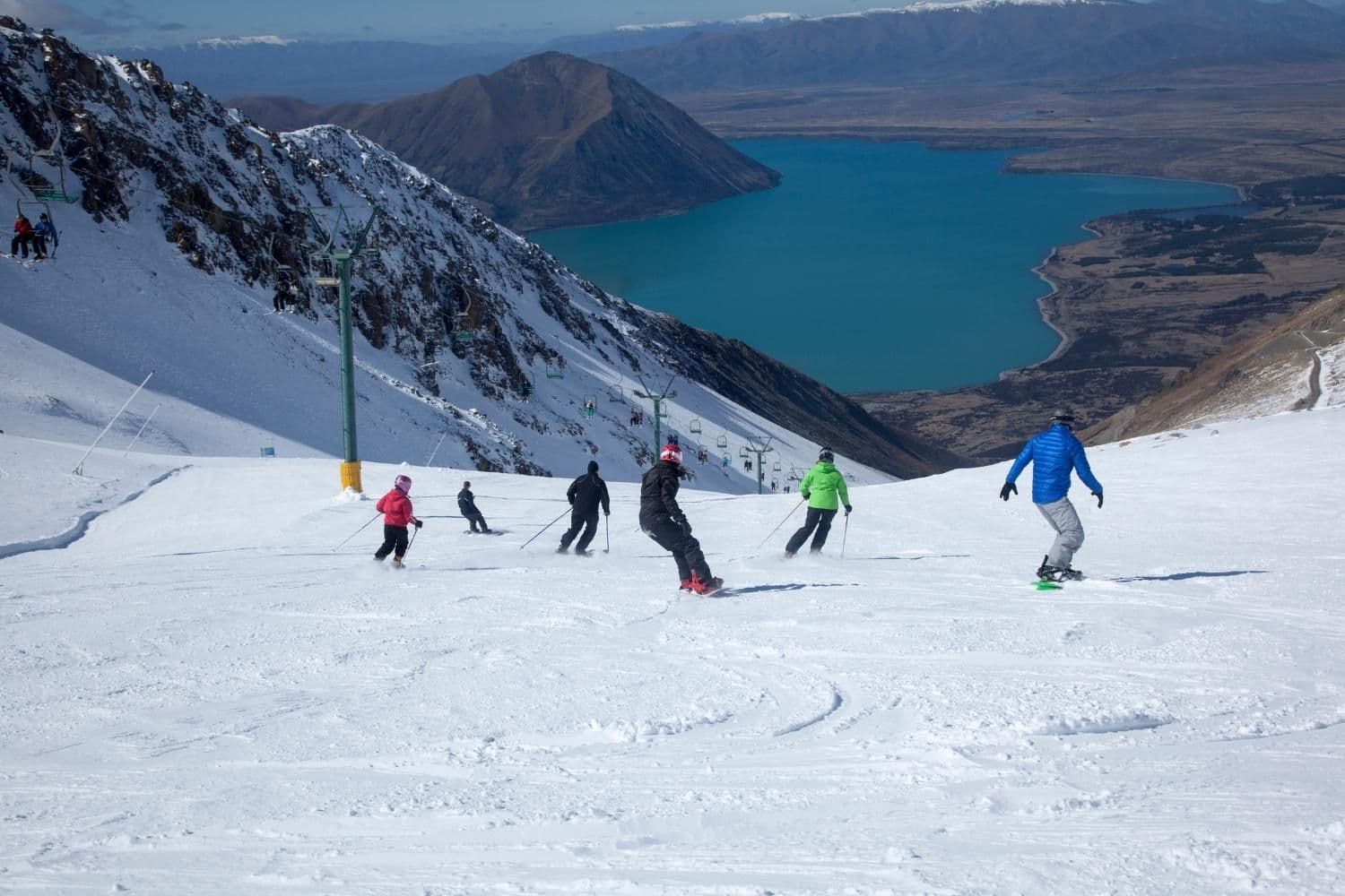 Ohau in New Zealand - a group of people skiing down a snowy slope.