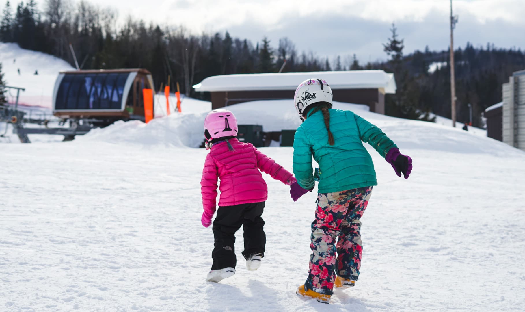 Winter sports scene at Sugarloaf Provincial Park, New Brunswick, with a family enjoying skiing, suggesting a ski resort or winter sports centre setup, possibly including a child learning to ski.