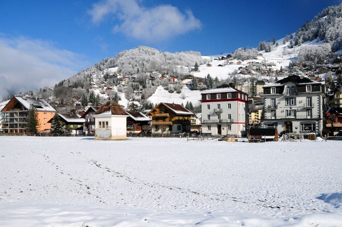 Brunni-Bahnen - Die Sonnenseite von Engelberg in Switzerland - a snow covered field with houses in the background.