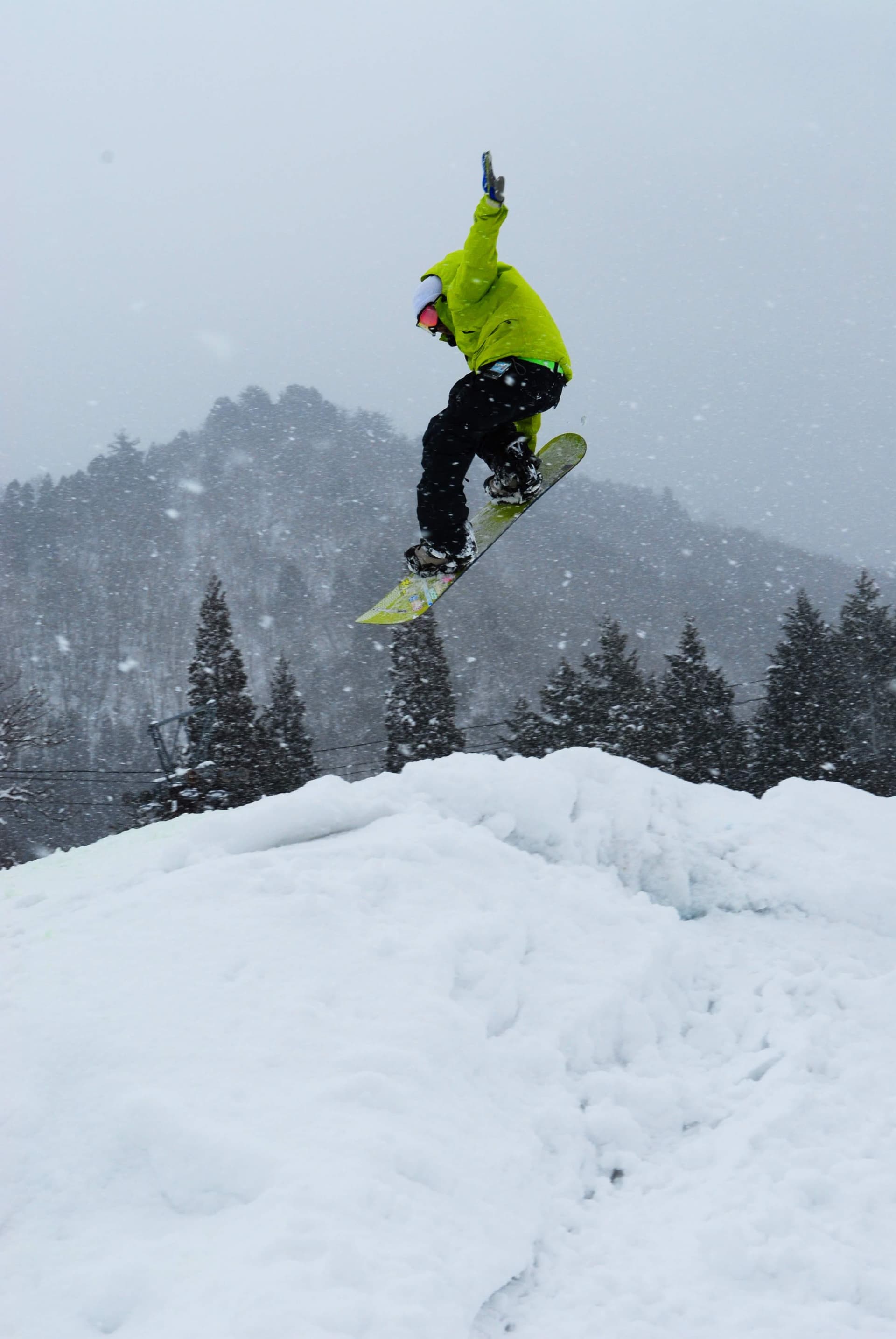 A snowboarder gliding down the snowy slopes in Hida Kawai, a scenic winter destination located in Chūbu, Hida, Gifu, on Japan's Honshu Island.