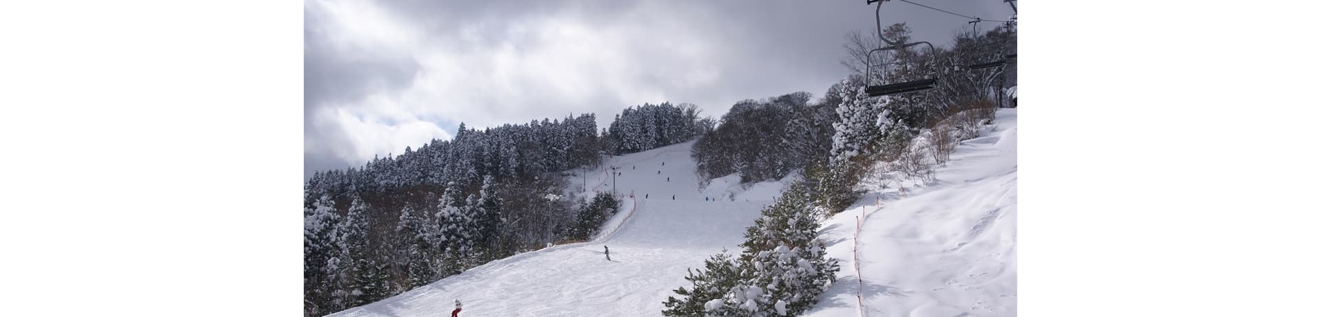 Megahiraonsen Megahira Ski Area in Japan - a person riding a snowboard down a snowy slope.