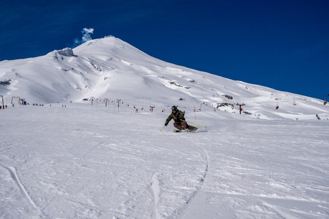 Volcan Villarrica Ski Center in Chile - a person riding a snowboard down a snowy slope.