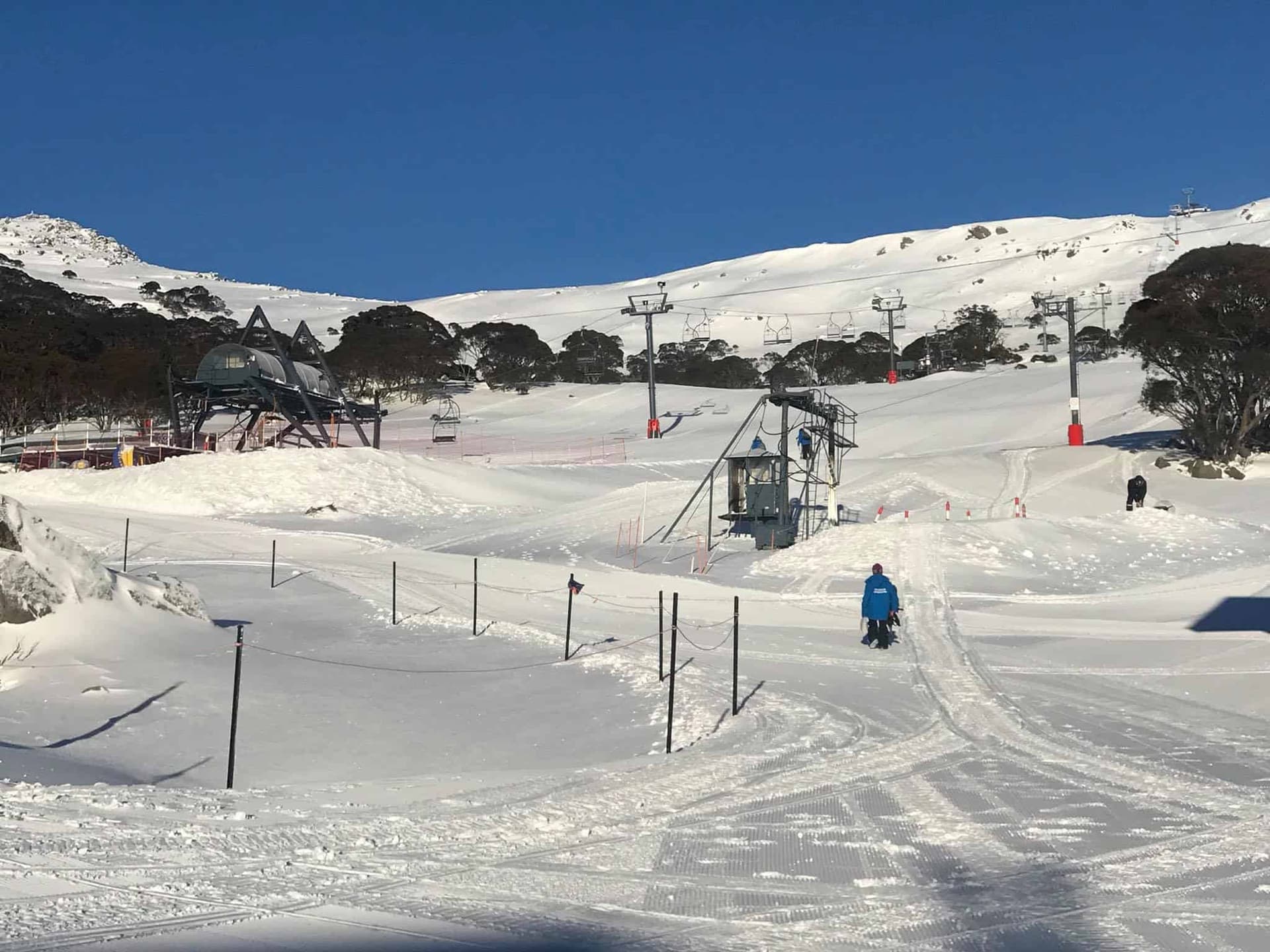 Charlotte Pass in Australia - a man riding a snowboard down a snowy slope.