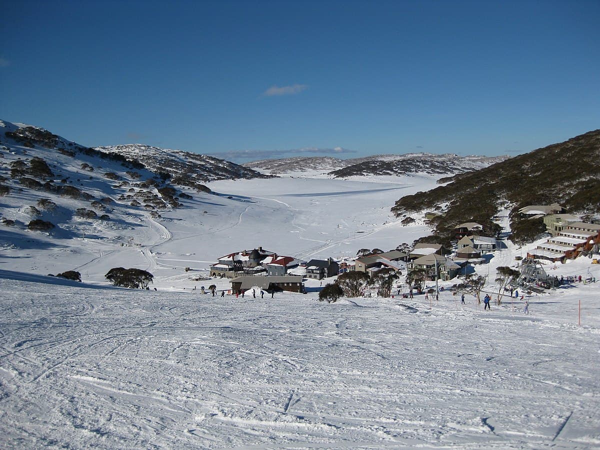 Charlotte Pass in Australia - a group of people skiing down a snow covered mountain.