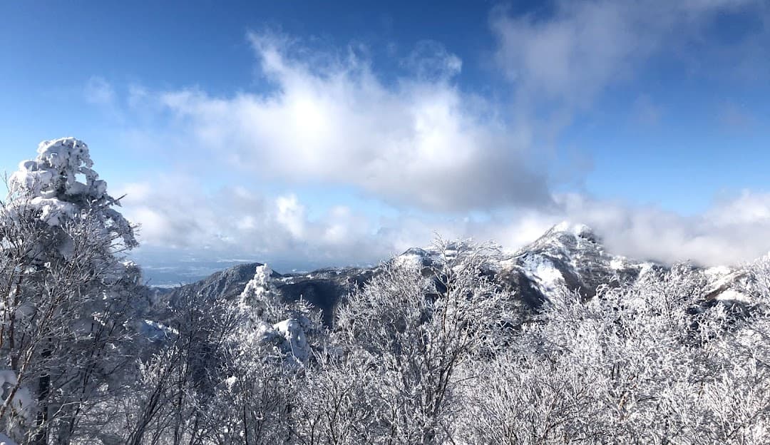 Stunning winter scenery at Manza Onsen in Japan, featuring a picturesque snowy mountain and a vibrant winter sports scene.