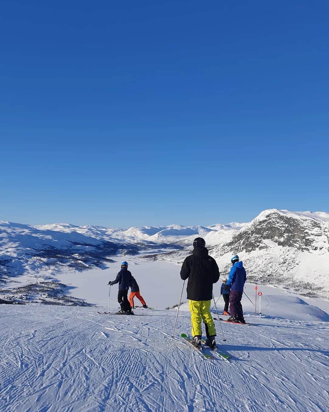 Tyin-Filefjell in Norway - a group of people skiing down a snowy slope.