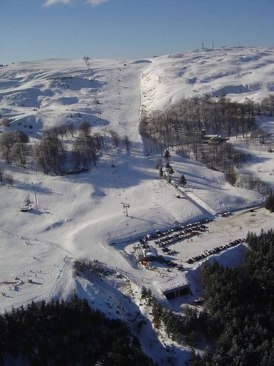 View of Risalita sciistica Carpegna - Eremo ski resort in Italy featuring a traditional chalet ski lift & bustling winter sports scene.