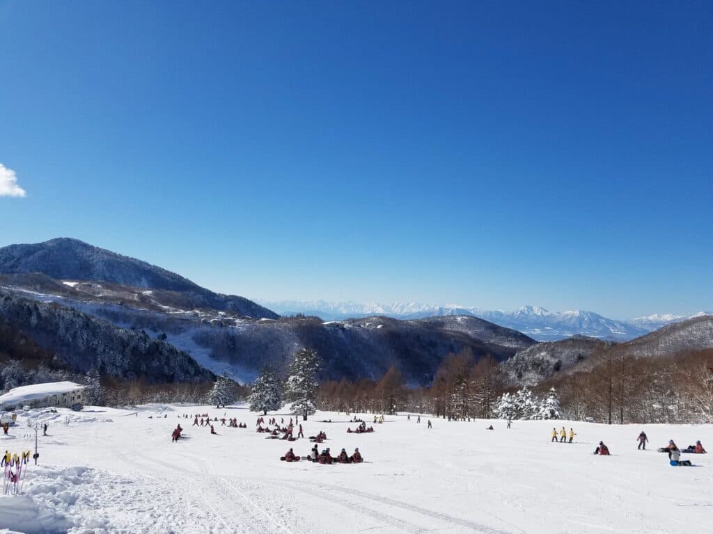 Tanne no mori Okojo in Japan - a group of people riding down a snow covered slope.