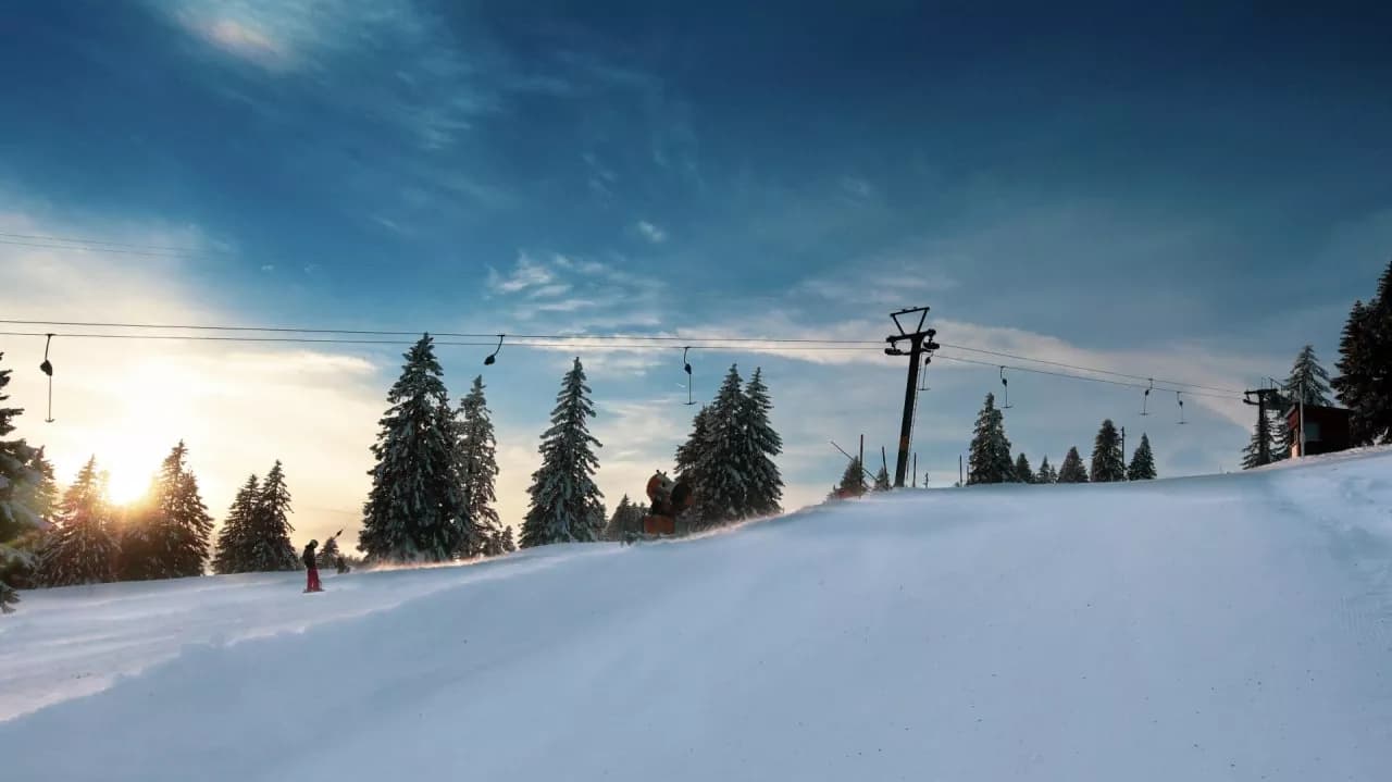 Image of a lively winter sports scene at the Ste-Croix - Les Rasses ski resort in Switzerland, showcasing vibrant ski slopes, a distant ski lift, amidst enticing winter scenery.