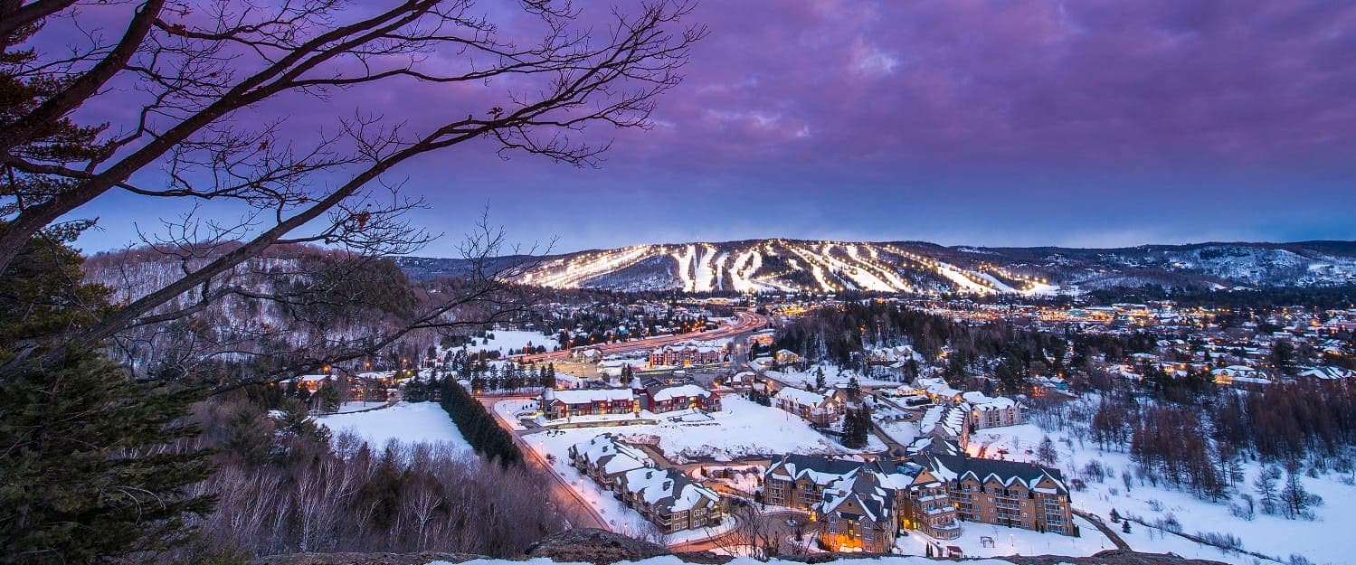 Sommet Gabriel in Canada - a view of a town in the mountains at dusk.