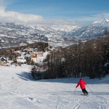 Scenic view of Laye ski resort in France showcasing a vibrant winter sports scene. Skiers are seen enjoying the slopes near a charming chalet. Perfect for winter sport enthusiasts.