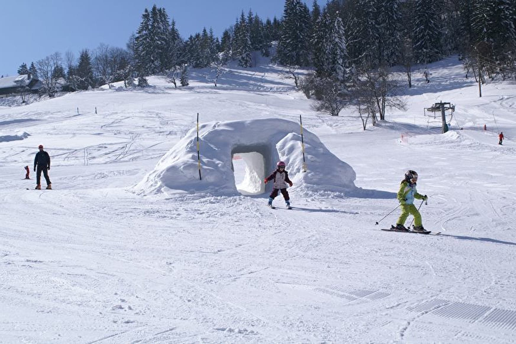 La Forclaz in Switzerland - a group of people skiing down a snow covered hill.