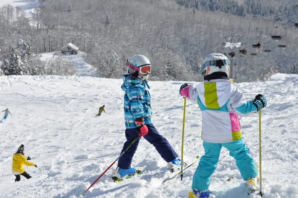 Asahi Shizen in Japan - a group of children skiing down a snowy hill.