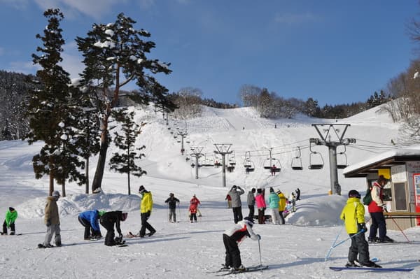 Asahi Shizen in Japan - a group of people skiing down a hill.