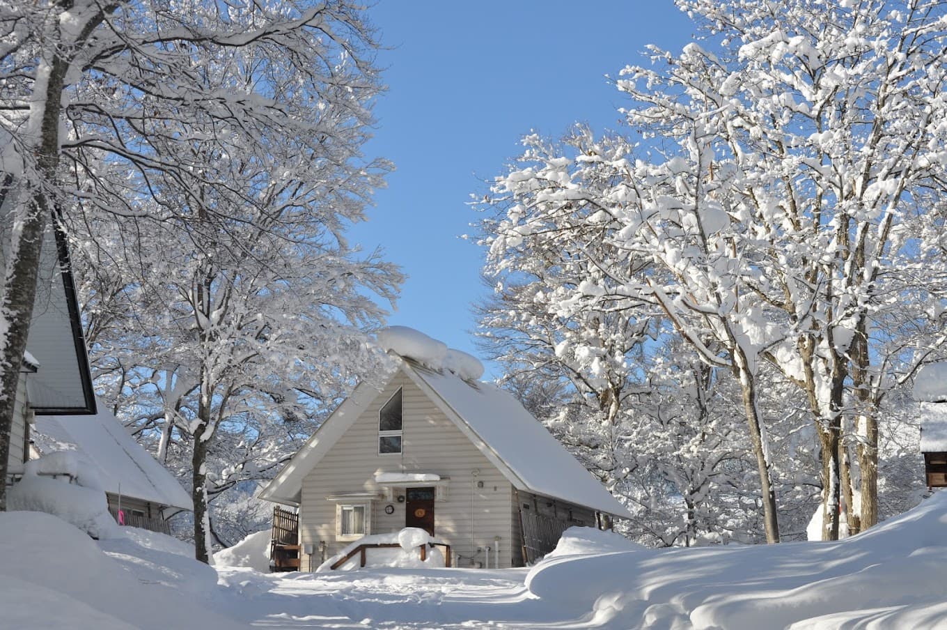 Asahi Shizen in Japan - a house covered in snow on a sunny day.