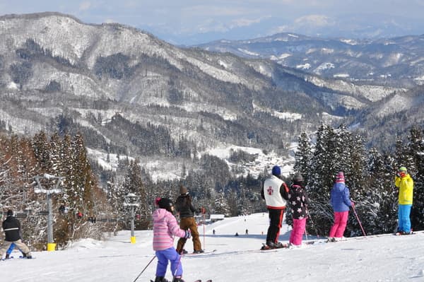 Asahi Shizen in Japan - a group of people skiing down a mountain.