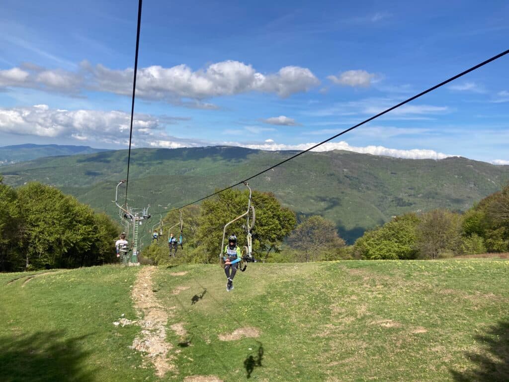 Seggiovia di Caldirola in Italy - two people on a ski lift in the mountains.