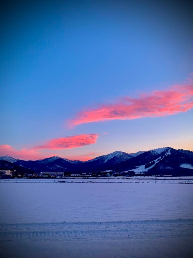 Minami Furano in Japan - the sun is setting over the mountains in the distance.