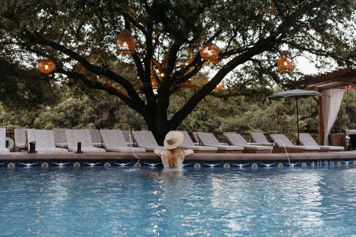 Snowstar in USA - a pool with chairs and umbrellas next to a tree.