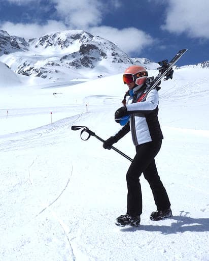 A skier enjoying a descent on the snowy slopes of Cerler, a popular ski resort in Aragon, Spain. Cozy chalets can be seen in the background, creating a beautiful winter sports scene.