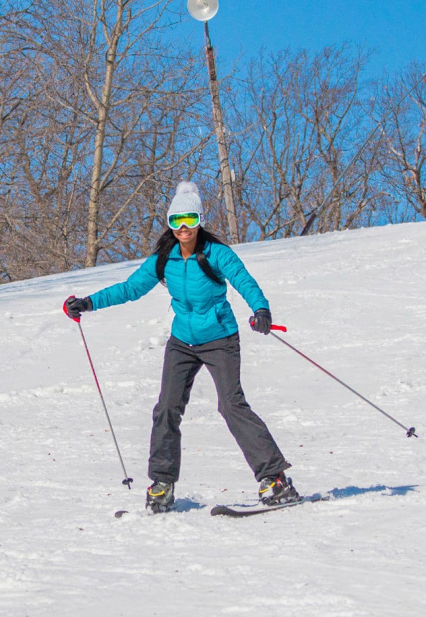 Wild Mountain in USA - a woman in a blue jacket skiing down a hill.
