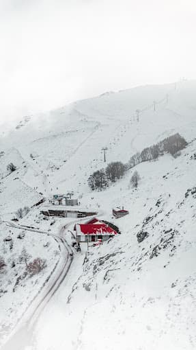 Bruncu Spina in Italy - a red house in the middle of a snowy mountain.