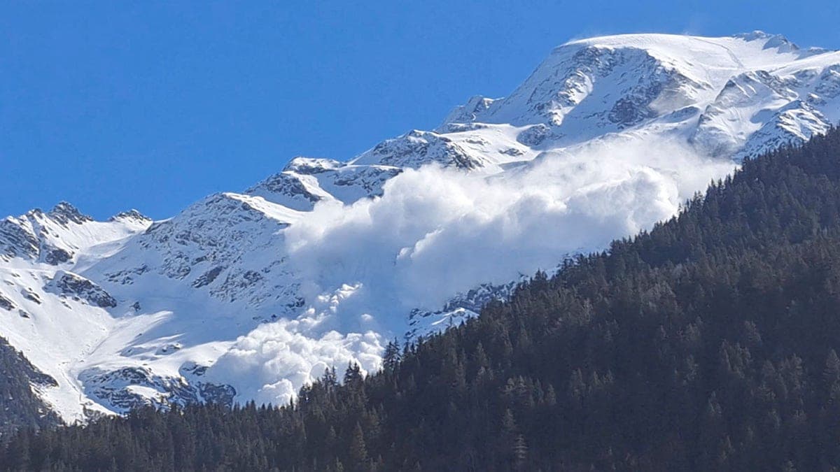 Domaine Skiable des Contamines Montjoie in France - a snow covered mountain with trees in the fore.