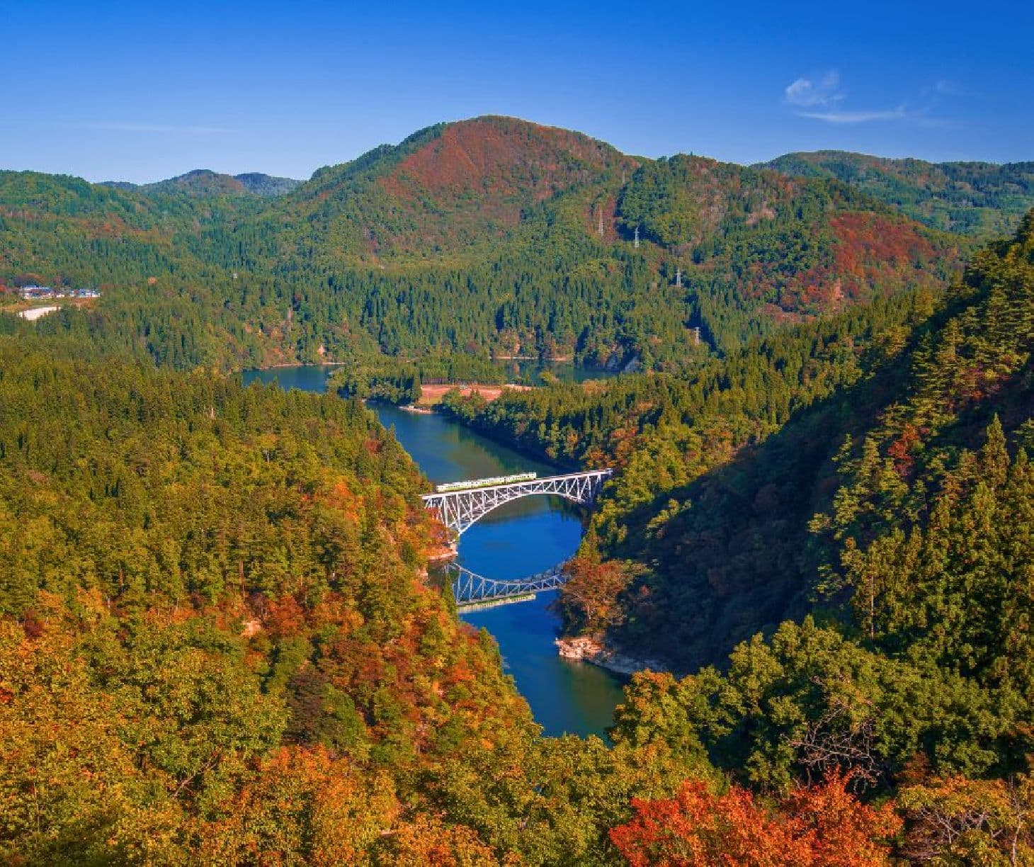 Tadami in Japan - a bridge over a river surrounded by trees.