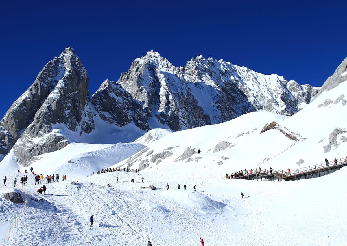Alshan Alpine in China - a group of people skiing down a snowy mountain.