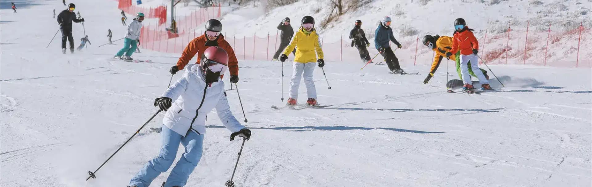 Alshan Alpine in China - a group of people skiing down a snowy slope.