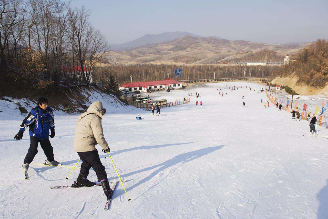 Alshan Alpine in China - a group of people skiing down a hill.