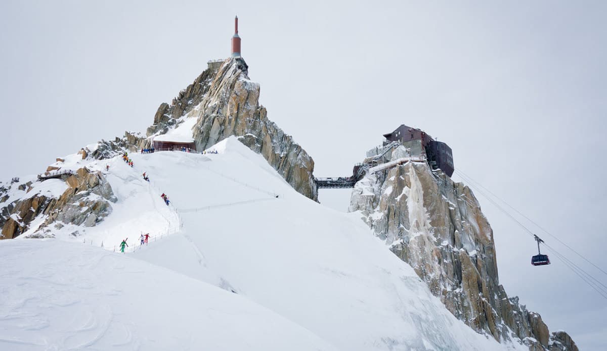 Aiguilles in France - a group of people climbing up a snowy mountain.