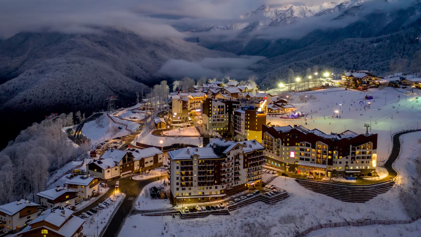 Rosa Khutor in Russia - a snowy town in the mountains at night.