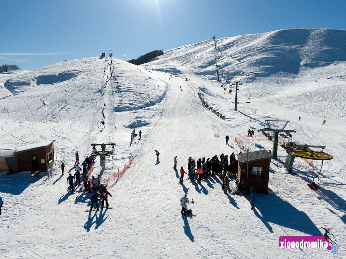 Lailia in Greece - a group of people skiing down a snowy hill.